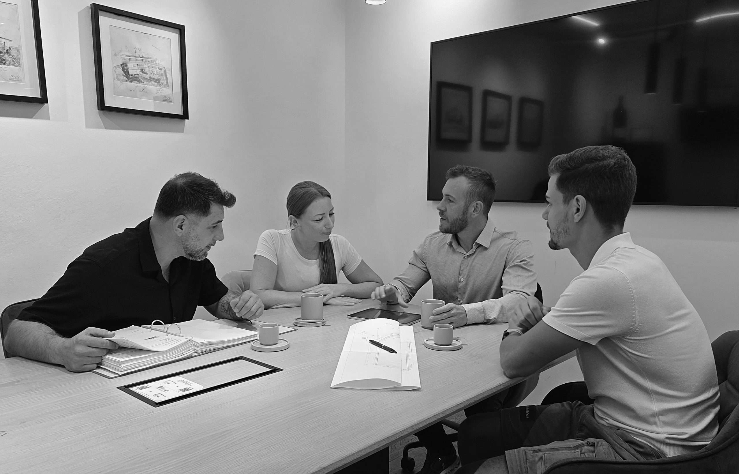 Besprechung am Tisch mit Planunterlagen
